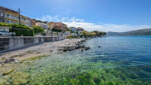 Nyilvánvaló, hogy a vízpartról nyíló kilátás épületeket, sziklás partot és egy nyugalmas tengert ábrázol.