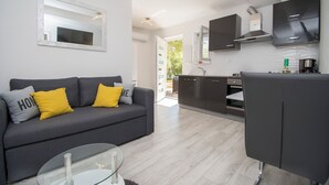 A modern living room with a grey sofa, yellow cushions, and a glass coffee table. - Apartment Ana (Jasenice)