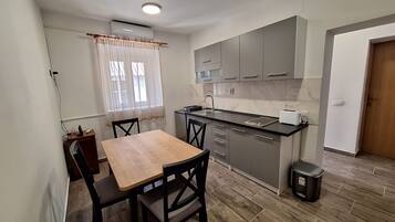 Apartamento (A1) | Cozinha privada | Geladeira, cooktop, torradeira, talheres/pratos/utensílios de cozinha