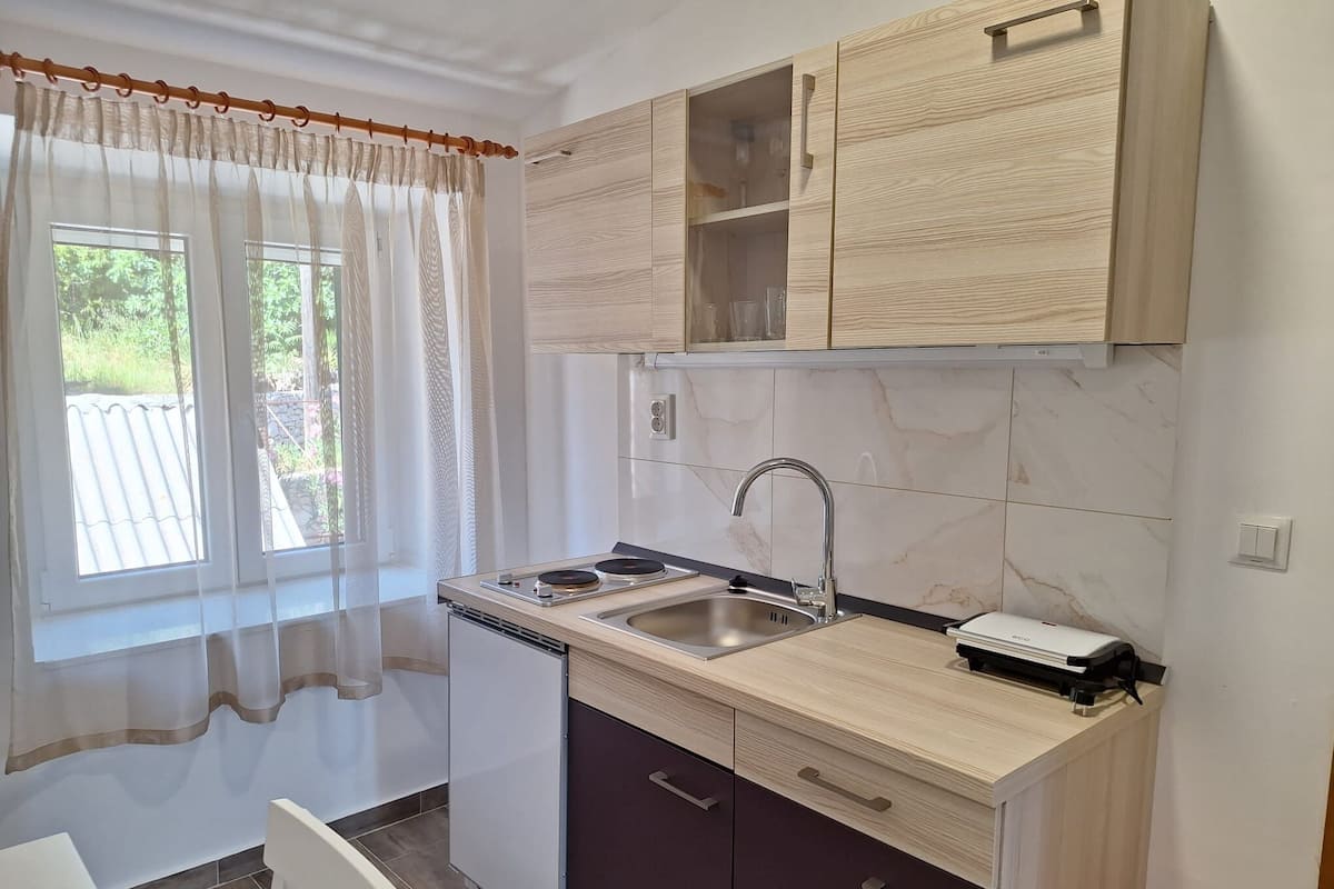 A compact kitchen with a built-in stove, sink, and cabinets.