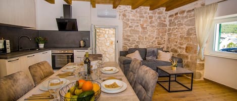 A cozy dining area with a stone wall, a stone fireplace, and a view of the outdoors.