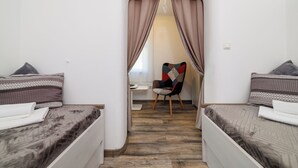 A bedroom with two beds, a chair, and a desk. - Apartment Lokvica (Omisalj)