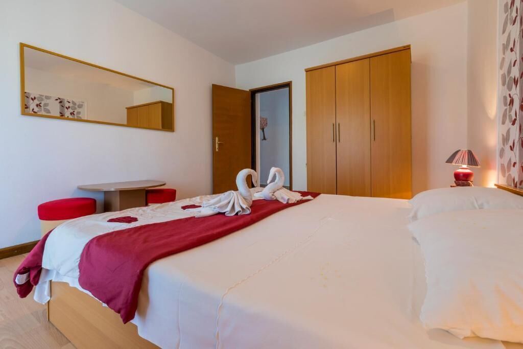 Une chambre d’hôtel comprenant un lit, un bureau, une chaise, une armoire et un miroir.