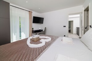 Une chambre d’hôtel moderne dotée d’un grand lit, d’un téléviseur à écran plat et offrant une vue sur l  ’extérieur par la fenêtre.