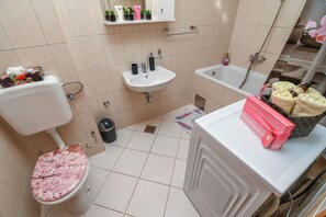 A bathroom with a toilet, sink, and bathtub. - Apartment Dani (Trogir)