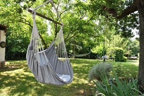 Una hamaca colgada de un árbol en un jardín exuberante.