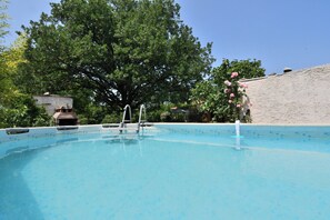 Una piscina al aire libre, sombrillas