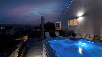 Ein Whirlpool mit einem steinbelagten Weg, der zu einem Haus führt.