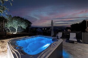 A hot tub with a view of a sunset and houses in the background. - Apartment Adria (Trogir)