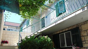 A residential building with a balcony, a staircase, and a pink bicycle. - Apartment Fran (Postira)