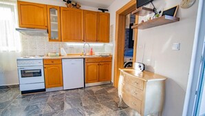 Una cocina compacta con armarios de madera, horno empotrado y lavavajillas.
