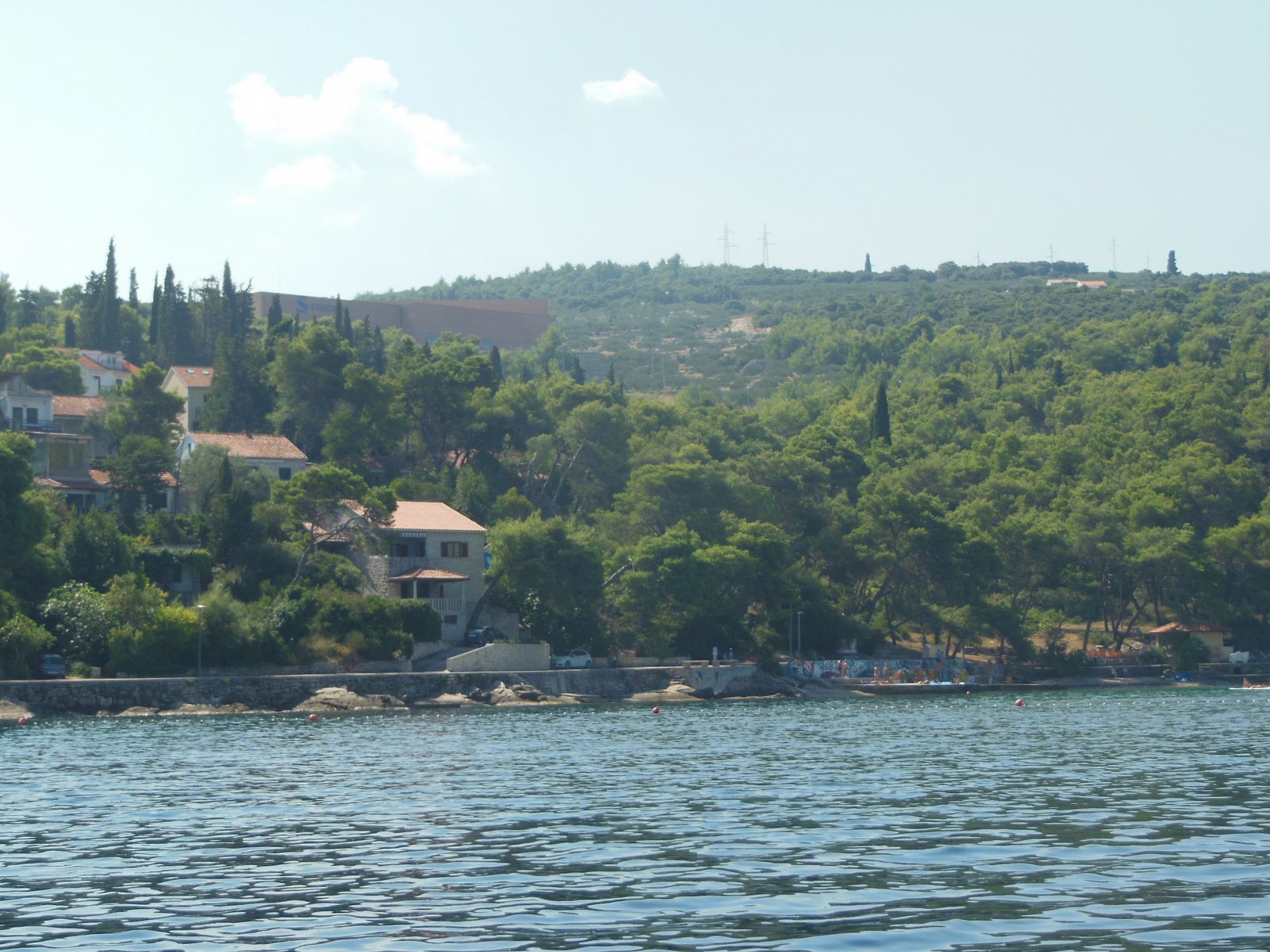 Une zone côtière avec des maisons, des arbres et une étendue d’eau.
