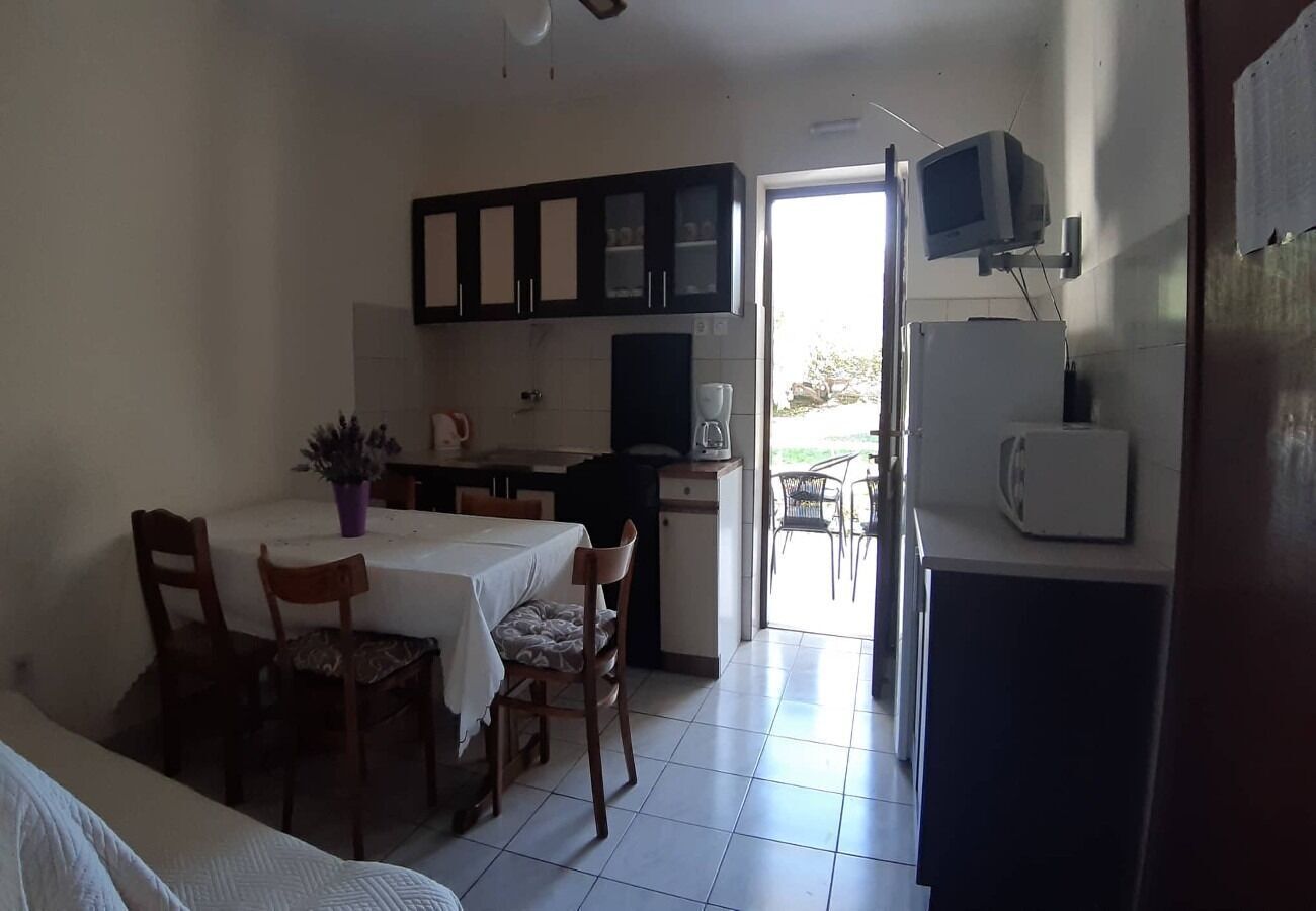A compact kitchen with a dining area, a small TV, and a refrigerator.