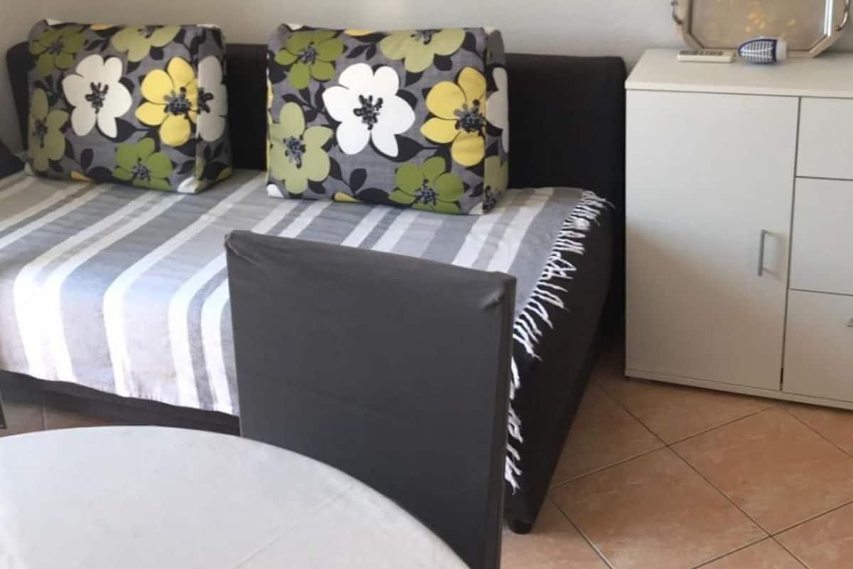 Una habitación con un conjunto de sofás, una mesa de comedor y un armario.