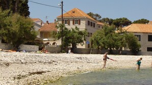 Una playa con un edificio de piedra al fondo.