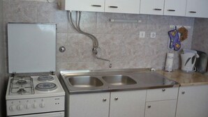 A kitchen with a stove, sink, and cabinets. - Apartment Eta (Hvar)