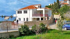 A two-story house with a stone facade, a red-tiled roof, and a balcony. - Apartment Eta (Hvar)