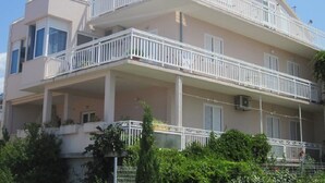 A multi-story building with balconies, air conditioning units, and a clear sky. - Apartments and Room Dar (Hvar)