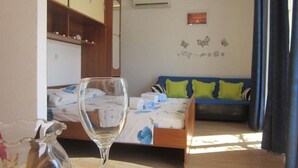 A room with a bed, a sofa, a glass of water, and a cabinet. - Apartments and Room Dar (Hvar)