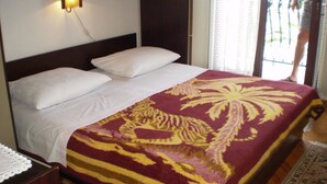 A bed with white linens and a tiger-patterned bedspread. - Apartment Smil (Sucuraj)