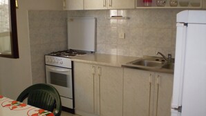 A kitchen with a stove, oven, sink, and cabinets. - Apartment Smil (Sucuraj)