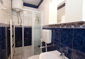 Ein Badezimmer mit Dusche, Toilette und Waschbecken.