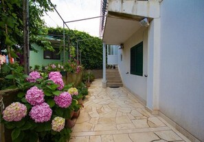 A stone-paved pathway leading to a building with a staircase. - Apartments Juri (Sucuraj)
