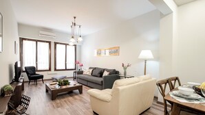 Un salon spacieux comprenant un canapé, un fauteuil, une table basse et une table à manger.