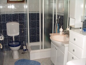 A bathroom with a toilet, sink, and shower area. - Apartments Dinka (Supetar)