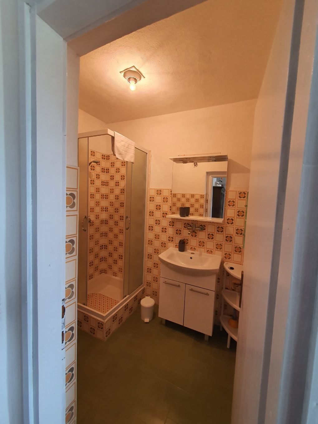 A bathroom with a shower, a sink, and a mirror.