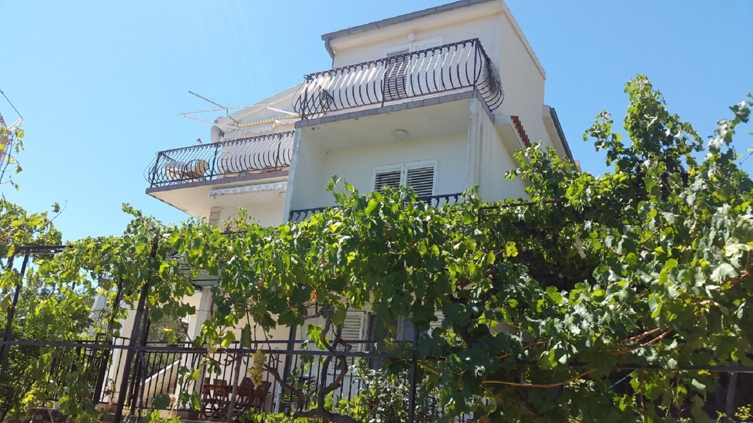 A two-story building with balconies and a fence in the foreground.