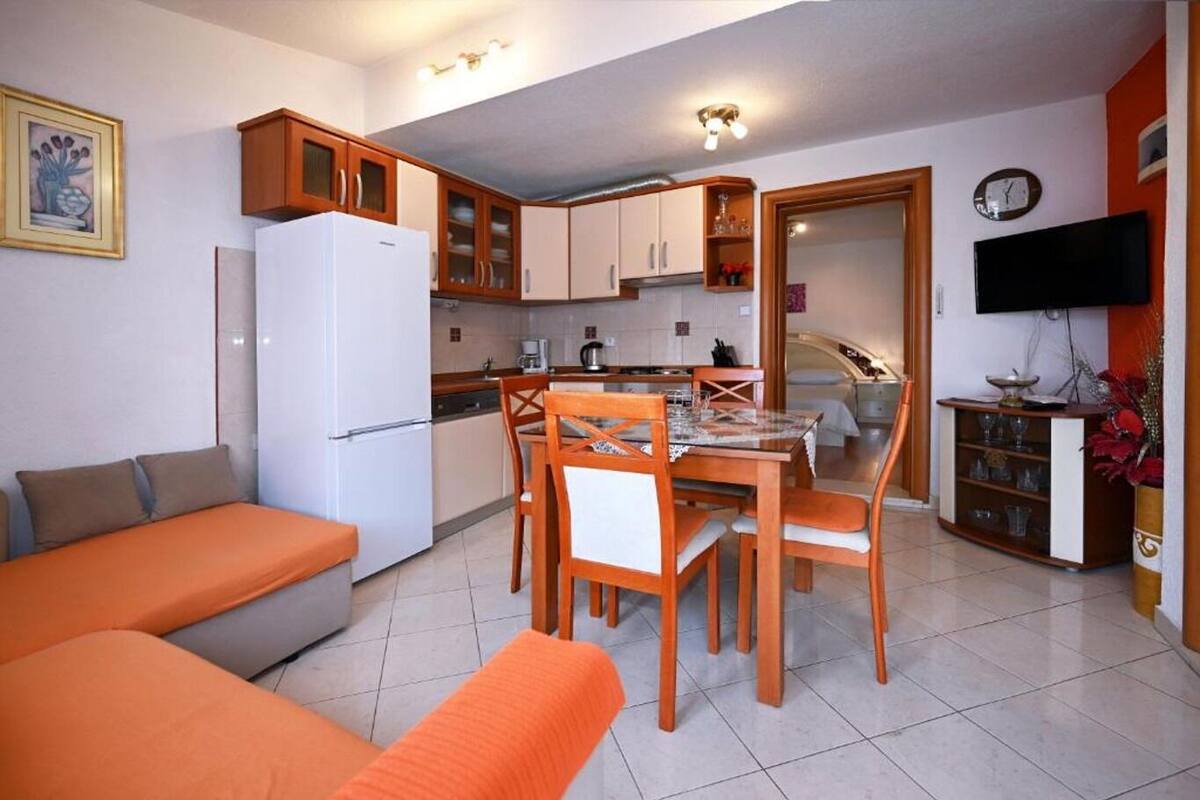 A compact living space with a kitchenette, a dining area, and a seating area with a sofa and chairs.