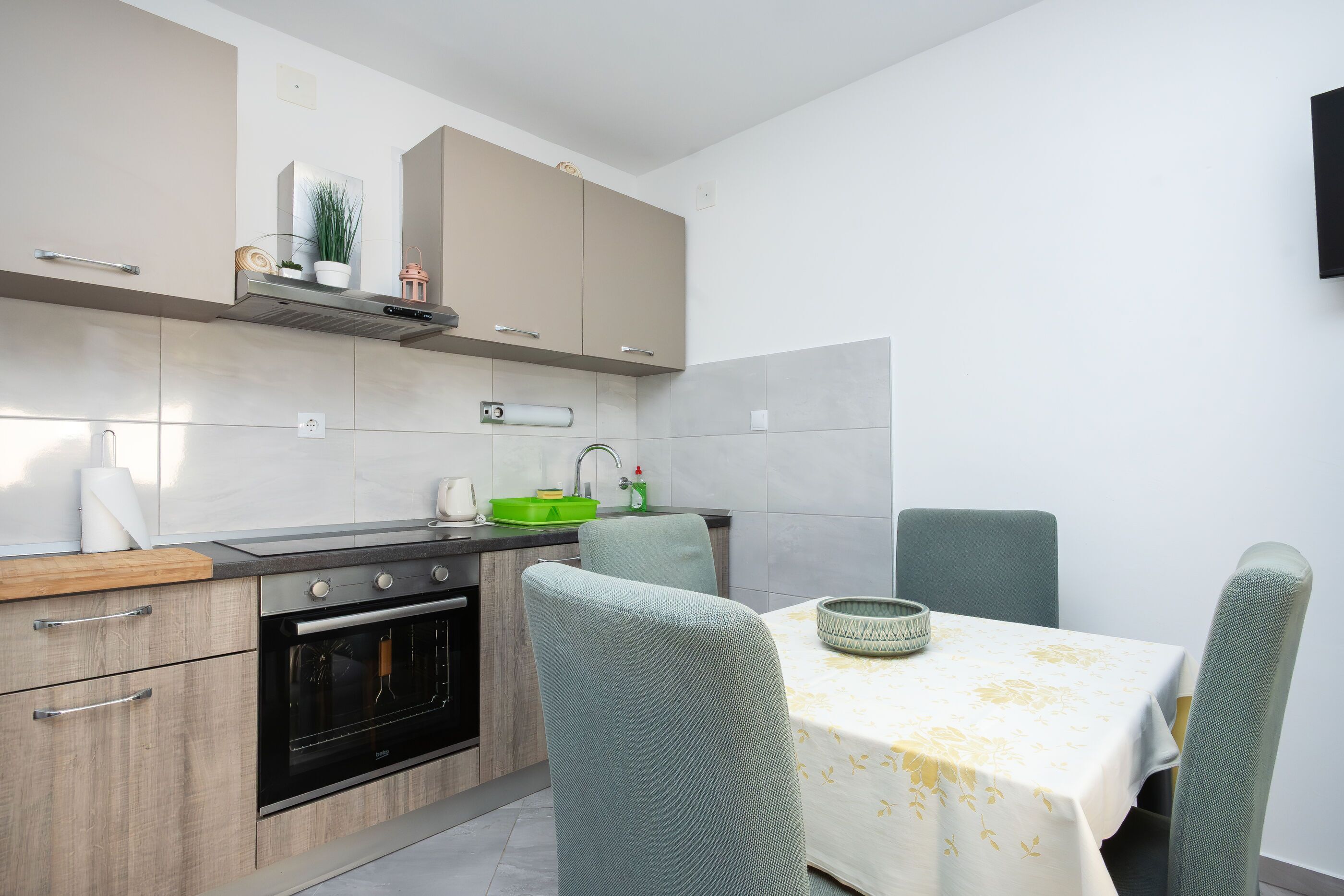 Une cuisine moderne avec un coin repas, comprenant des placards, un évier et des chaises.