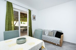 Una stanza con un tavolo da pranzo, un divano e vista sull'esterno.