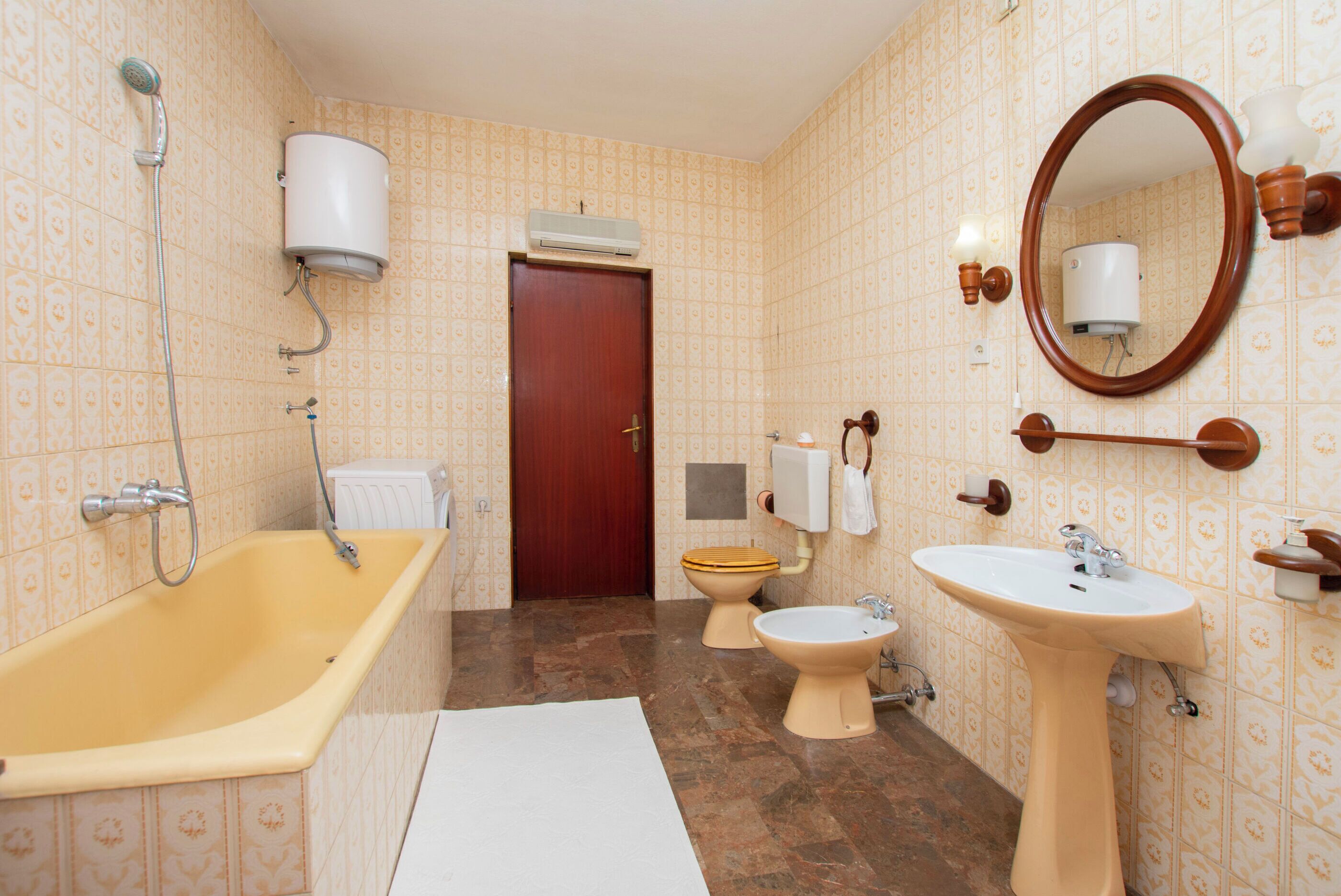 A bathroom with a bathtub, toilet, bidet, and sink.