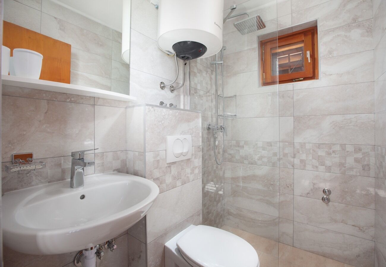 A modern bathroom with a sink, toilet, and shower.
