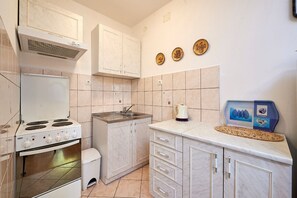 Apartment (A1) | Private kitchen | Fridge, stovetop, electric kettle, cookware/dishes/utensils - Apartment Ivanka (Trogir)