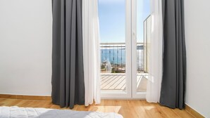 A room with a balcony, white curtains, and a wooden floor. - Apartments Rose (Seget)