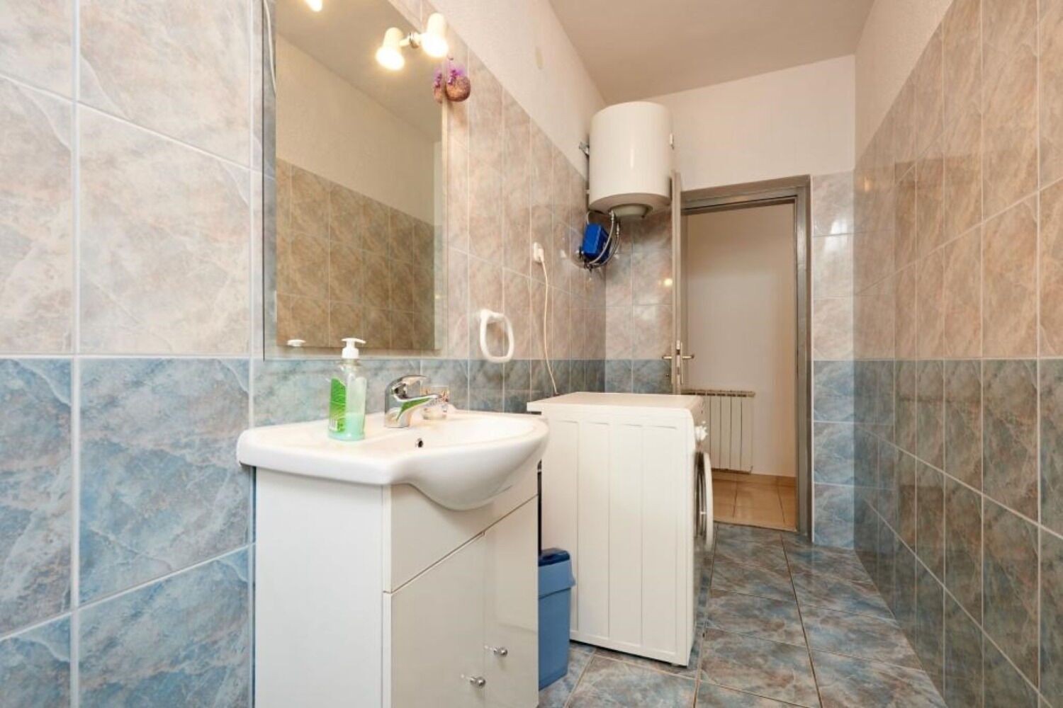 A bathroom with a white sink, a mirror, and a shower area.