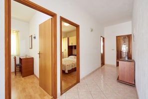 Ein Flur mit Holztüren, der zu einem Schlafzimmer und einem Badezimmer führt.