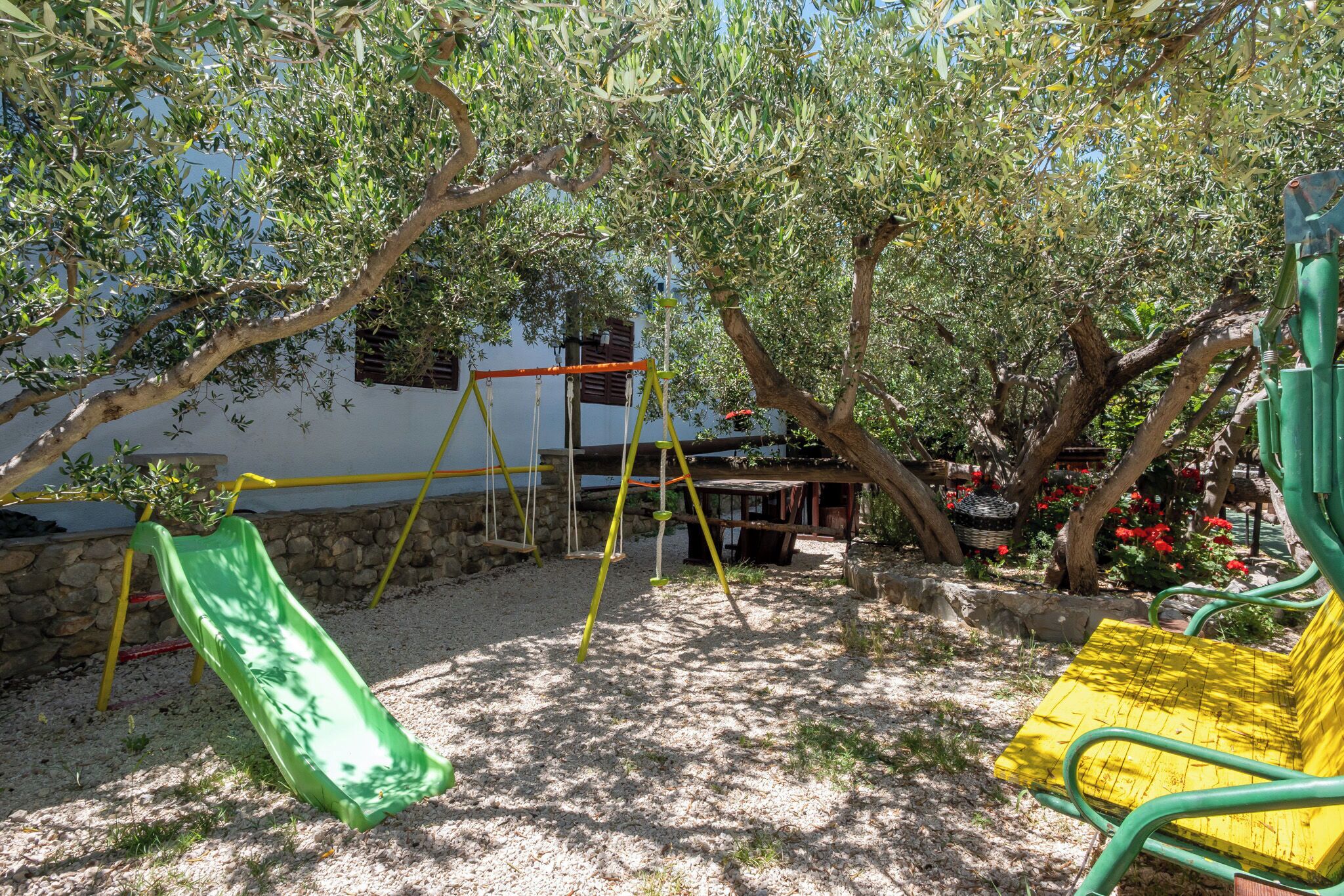 A playground with a slide, swings, and a bench.