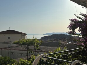 A residential area with buildings, a clear sky, and a distant view of the sea. - Apartments Sini (Makarska)