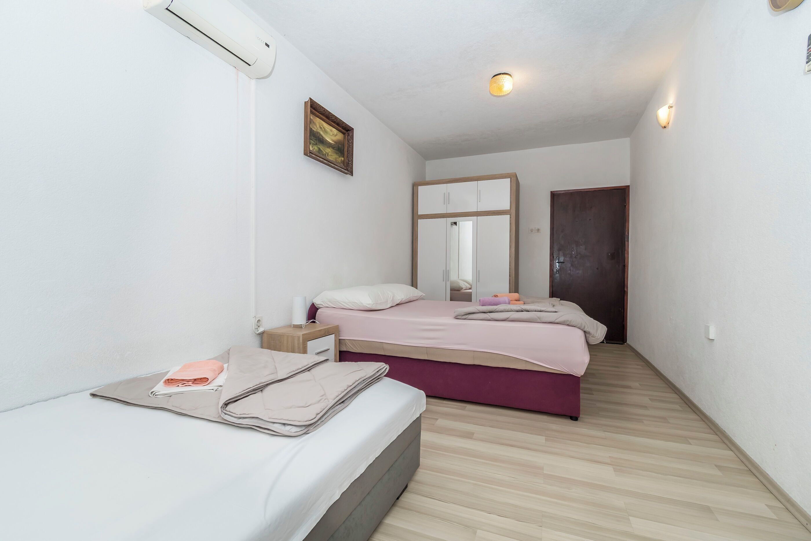 A bedroom with a bed, bedside table, and a wardrobe.