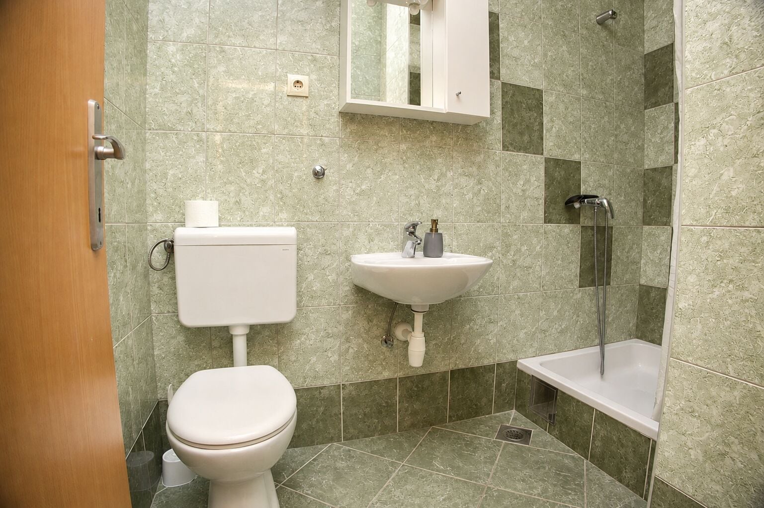 A bathroom with a toilet, sink, and shower.