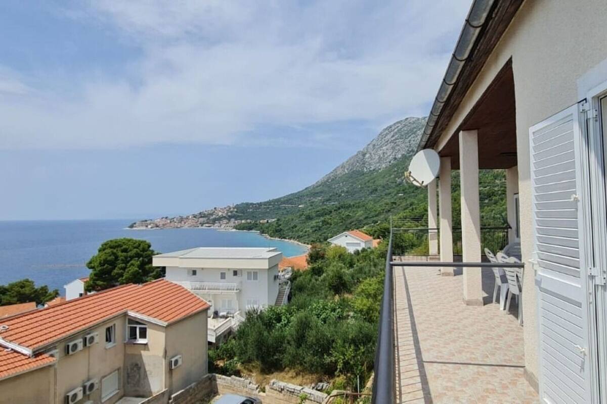 A balcony with a view of the sea and a mountain.