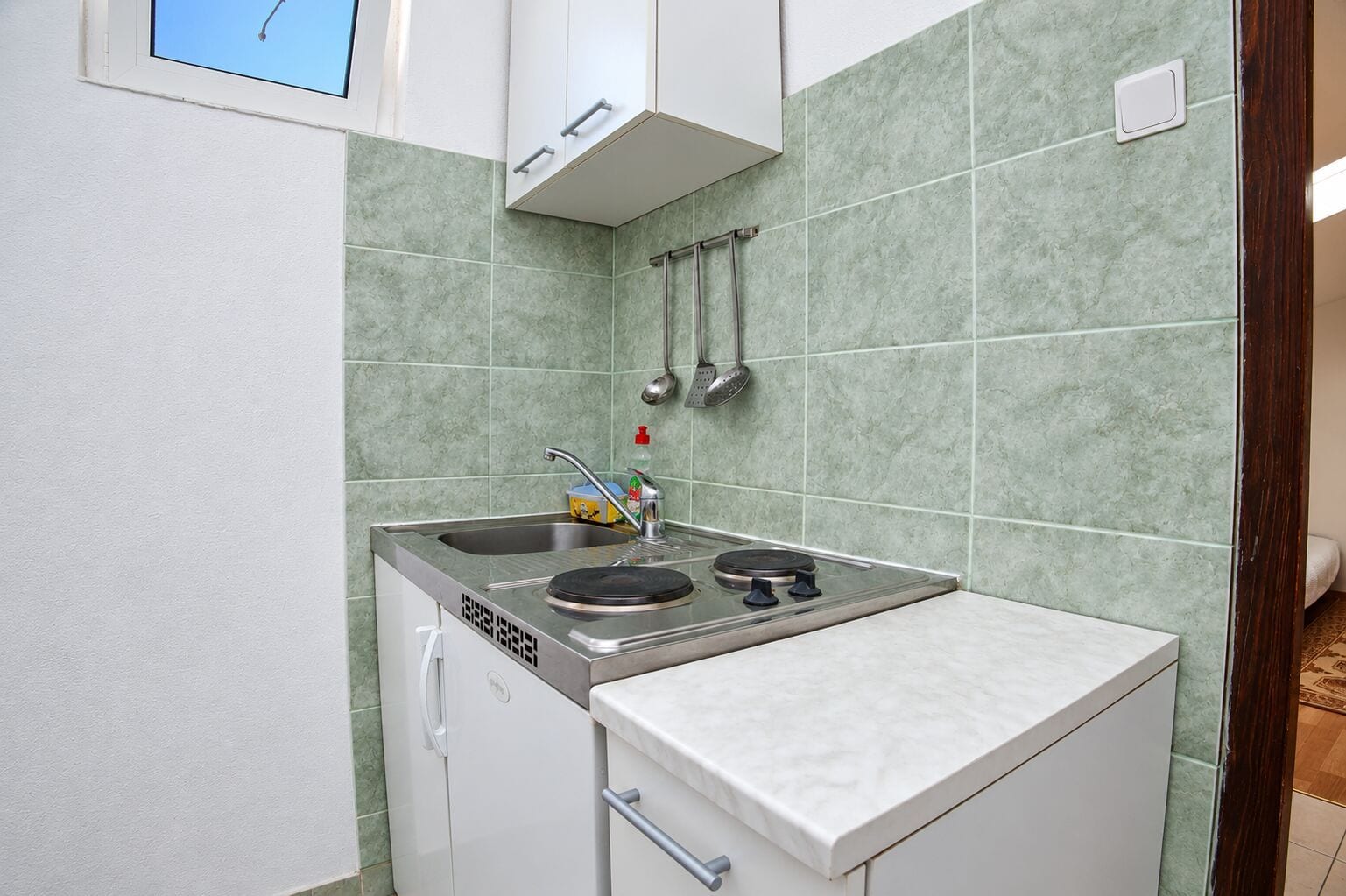 A compact kitchen with a gas stove, a sink, and a small countertop.