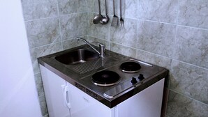 A compact kitchen with a sink, two burners, and a small refrigerator. - Apartments Nik (Gradac)