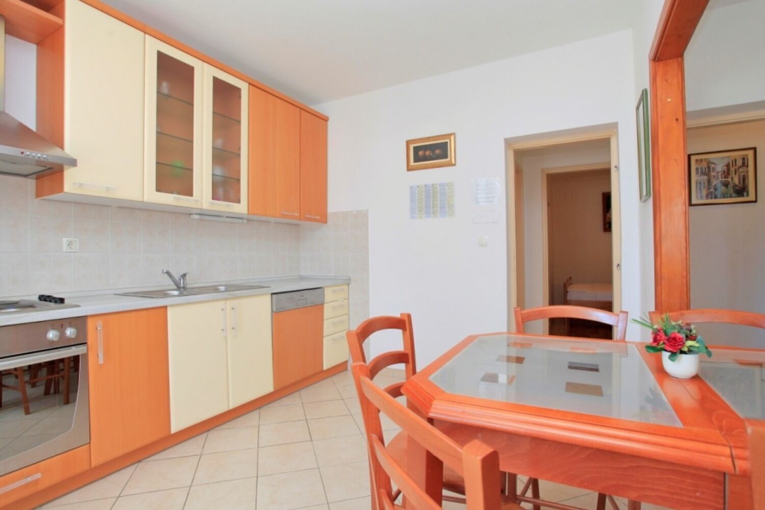 A kitchen with wooden cabinets, a stove, and a dining table with chairs.