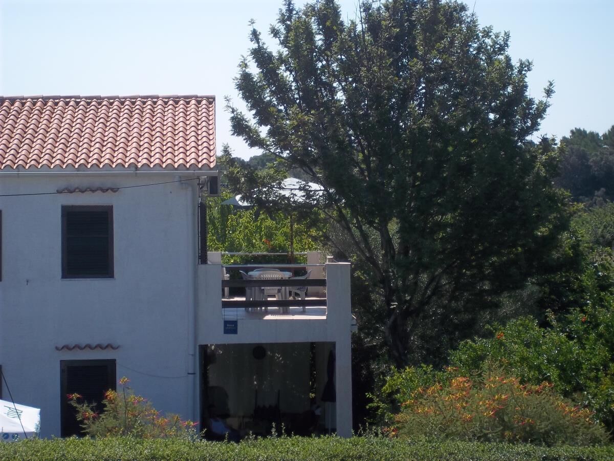 A two-story building with a tiled roof and a balcony.