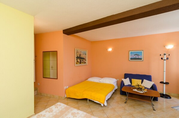 A room with a bed, a sofa, a small table, and a floor lamp. - Apartment Oli (Dubrovnik)